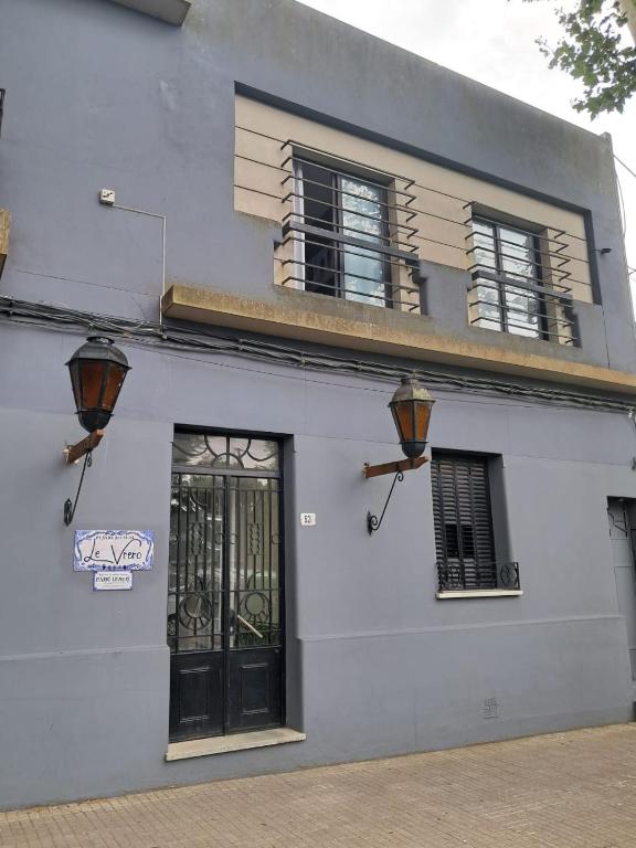 a white building with a door and windows at Le Vrero Boutique Hotel in Colonia del Sacramento
