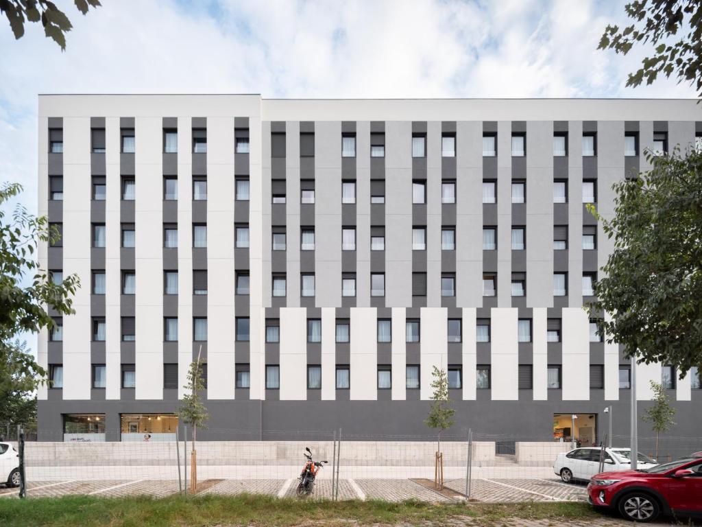 a large white building with cars parked in front of it at Stephouse Girona Tarradellas in Girona