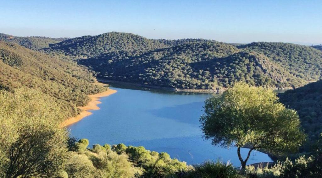 a view of a lake in the middle of a mountain at La Escapada in El Ronquillo