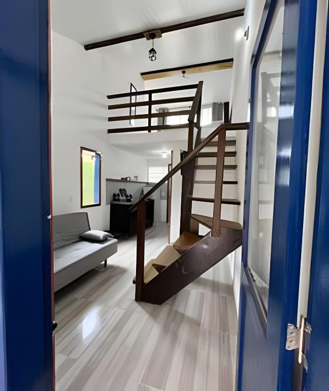 a room with a staircase and a living room at Casinhas da toca in Búzios