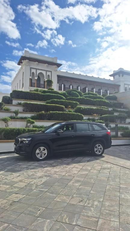 a black car parked in front of a building at Berradi Prestige Travel in Oulad Akkou
