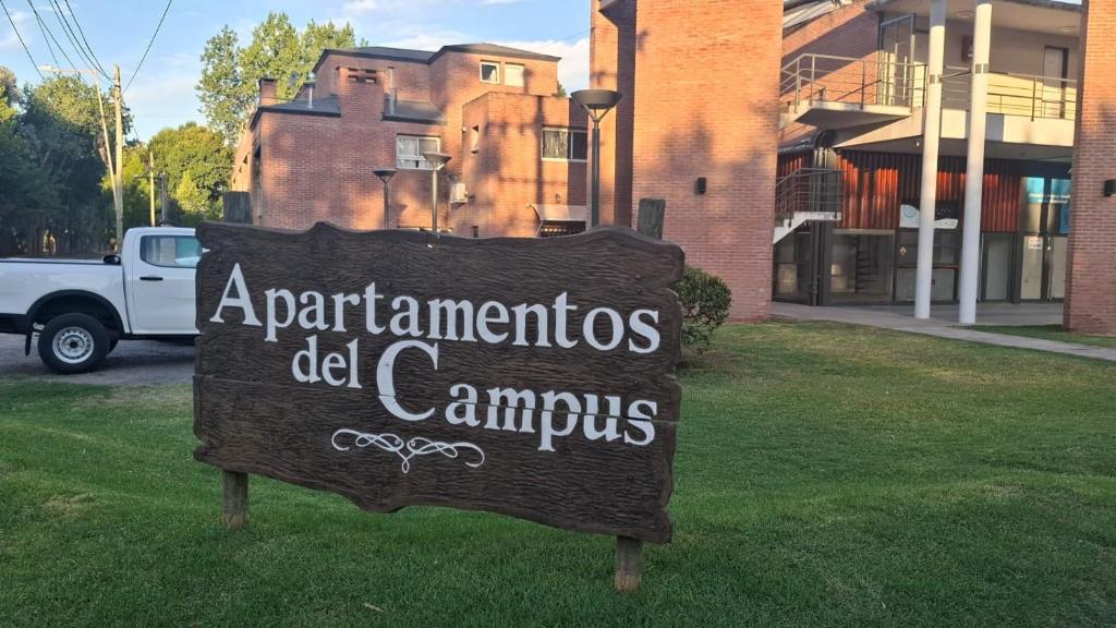 a sign in the grass in front of a building at Apartamentos del campus in Manzone