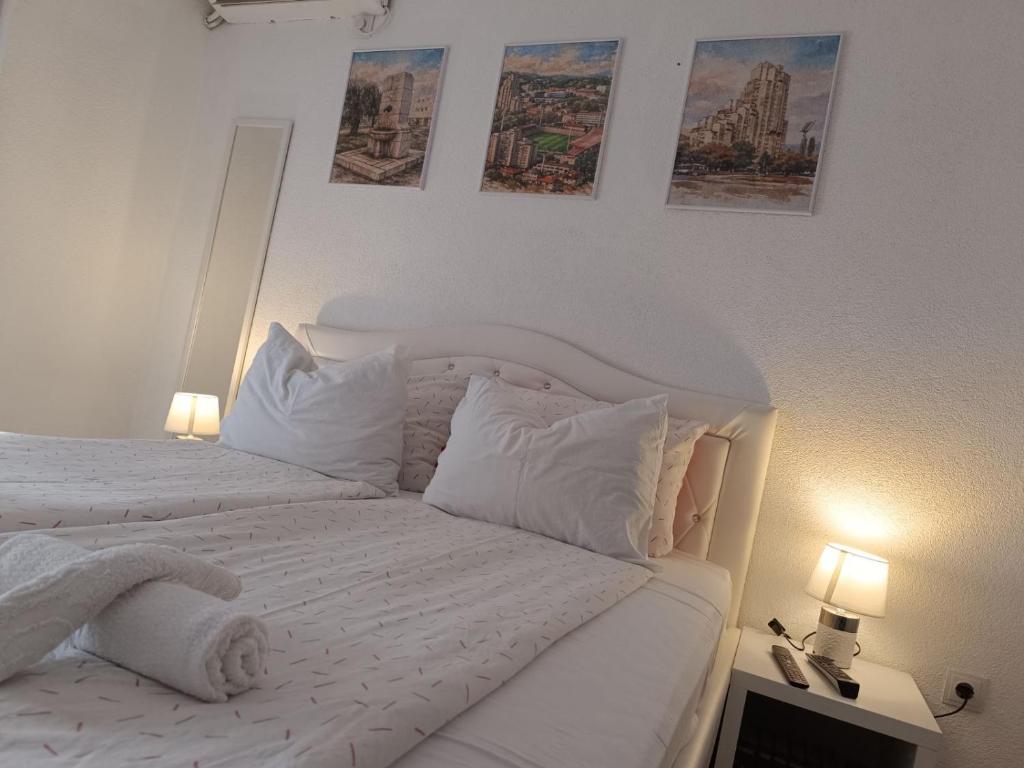 a white bedroom with a bed with white sheets and pillows at SWEET APT Zenica in Zenica