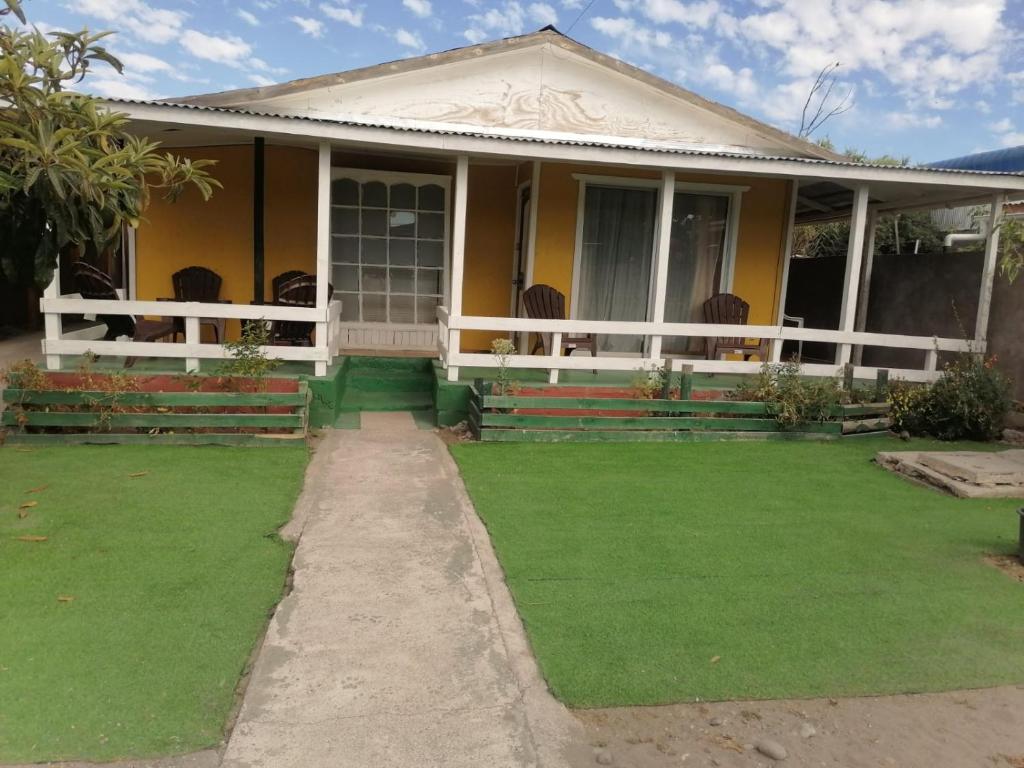 a house with a green lawn in front of it at Casa Lo Herrera in Isla de Maipo