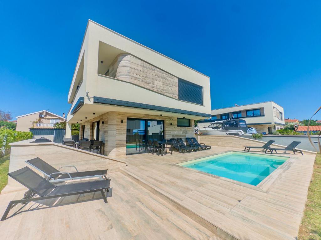 a villa with a swimming pool and a house at Villa Privlaka Travertino in Privlaka