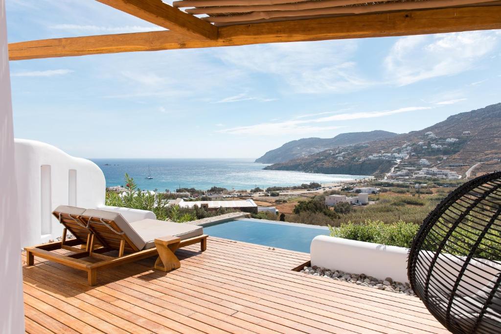 a wooden deck with a view of the ocean at Mileo Mykonos in Kalo Livadi