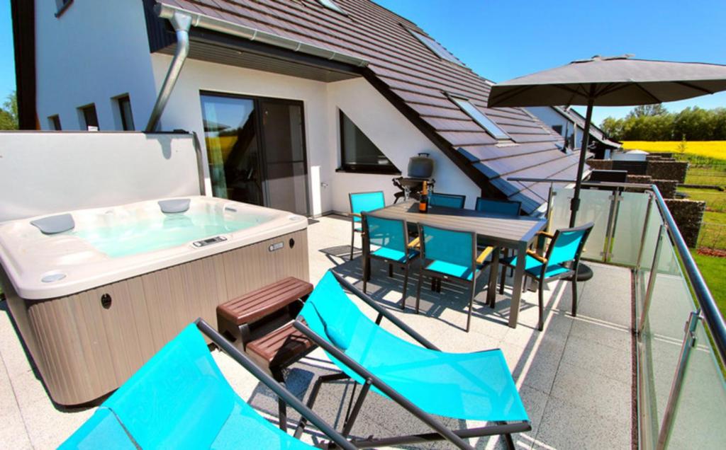 a patio with a hot tub and tables and chairs at Villa Aquila Luxus-Maisonette Ferienträume Dachterrasse in Göhren-Lebbin