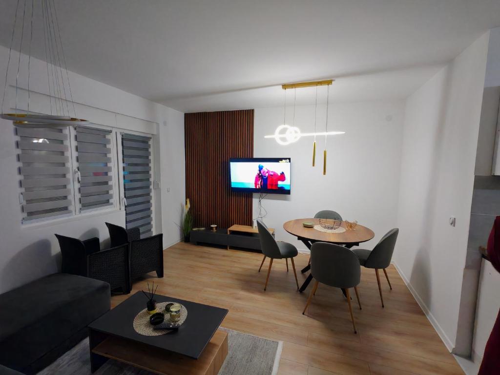 a living room with a table and chairs and a tv at Stan na dan Bor in Bor