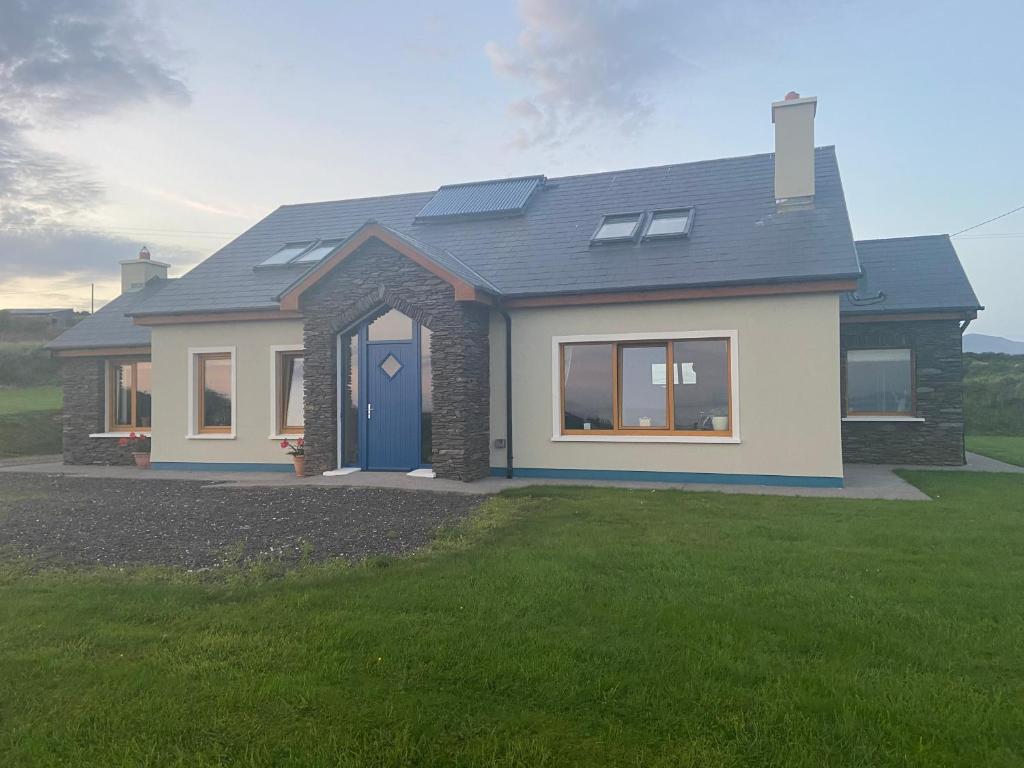 a house with a blue door in a yard at Skellig Sanctuary in Dingle
