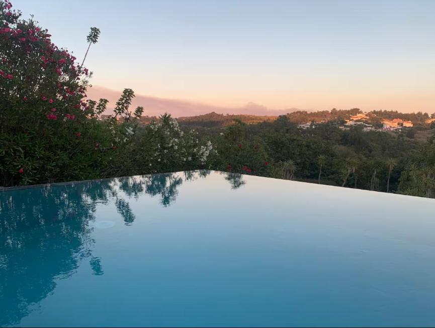 a swimming pool with a view of a city at Casa da Figueira in Ericeira
