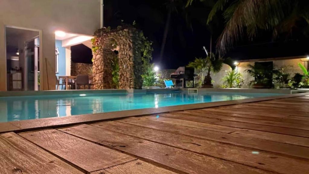 a swimming pool at night in a resort at MOOREA - Waterfall Pool Coconut House 1 in Pihaena