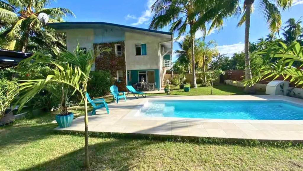 a villa with a swimming pool in front of a house at MOOREA - Coconut Pool House 4 in Pihaena