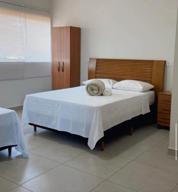 a bedroom with a bed with two towels on it at Hotel Cerrado in Iraí de Minas