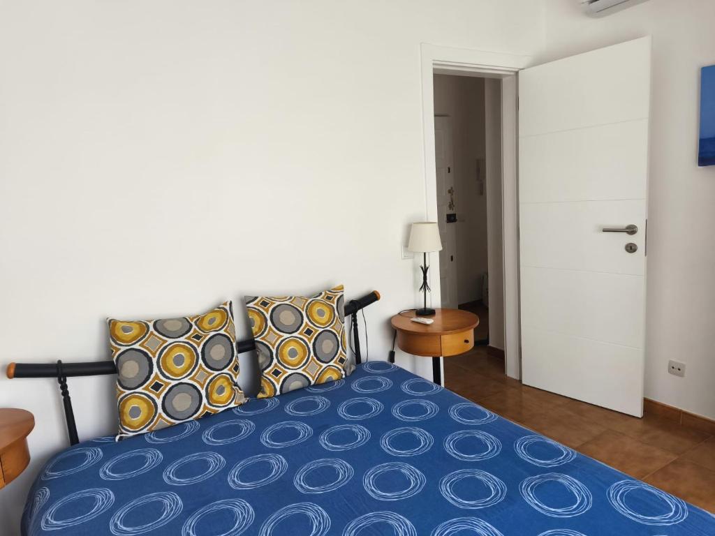 a bedroom with a bed with a blue comforter at Blue Apartment in Portimão