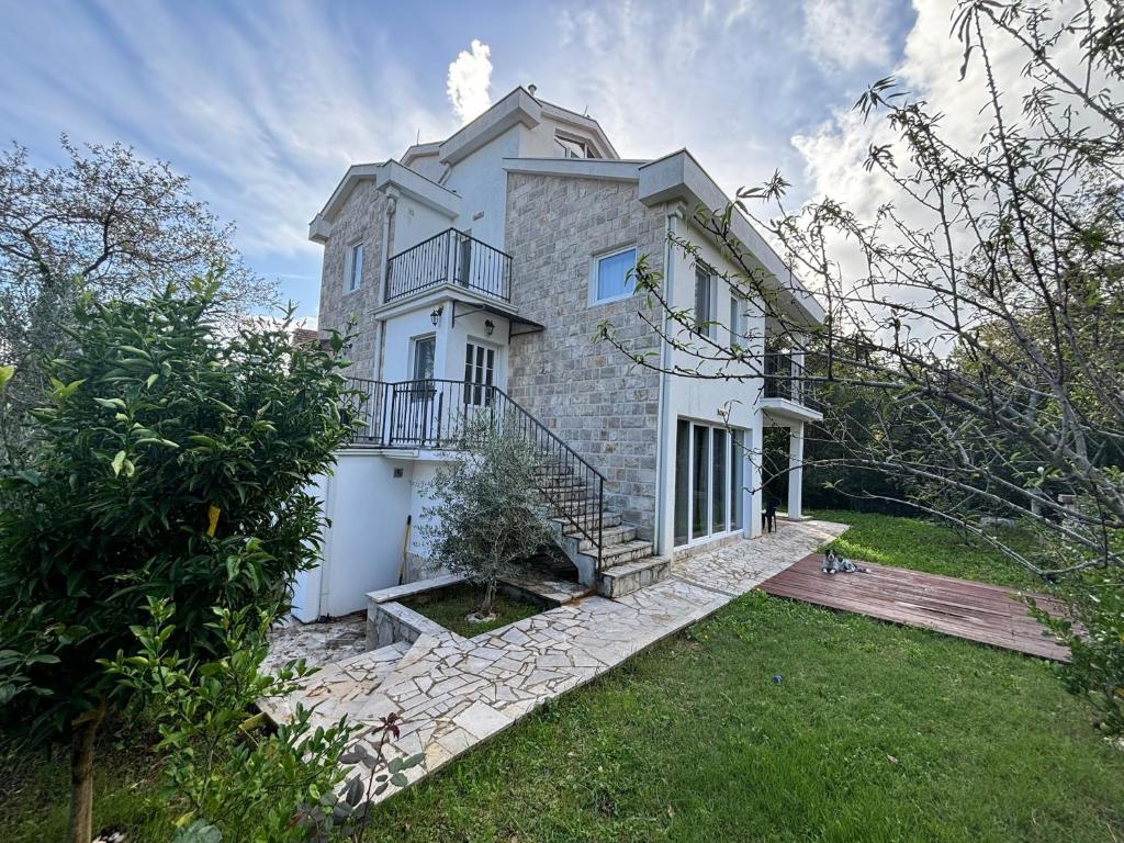 a large white house with a balcony on top at Patrick House in Tivat