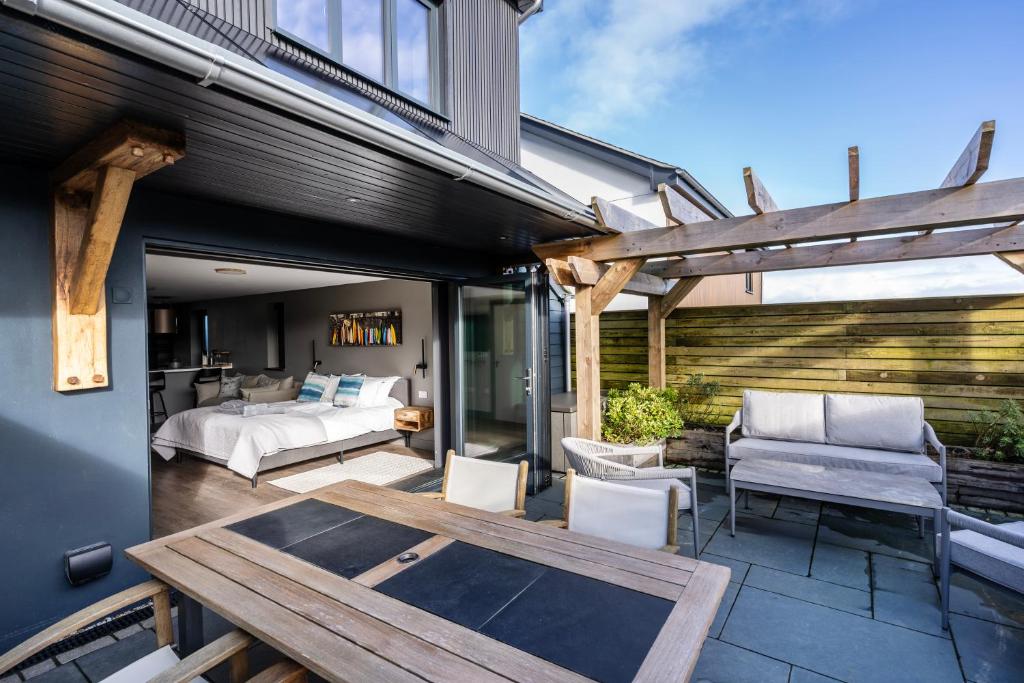a patio with a bed and a table at Uno Carbis Bay - Boutique Luxury Accommodation in Carbis Bay