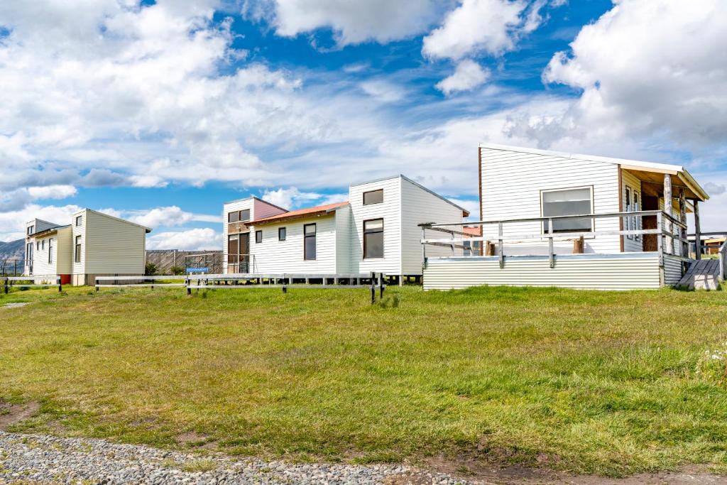 a group of houses on a grass field at Kayenwuouk, Puerto Natales in Puerto Natales