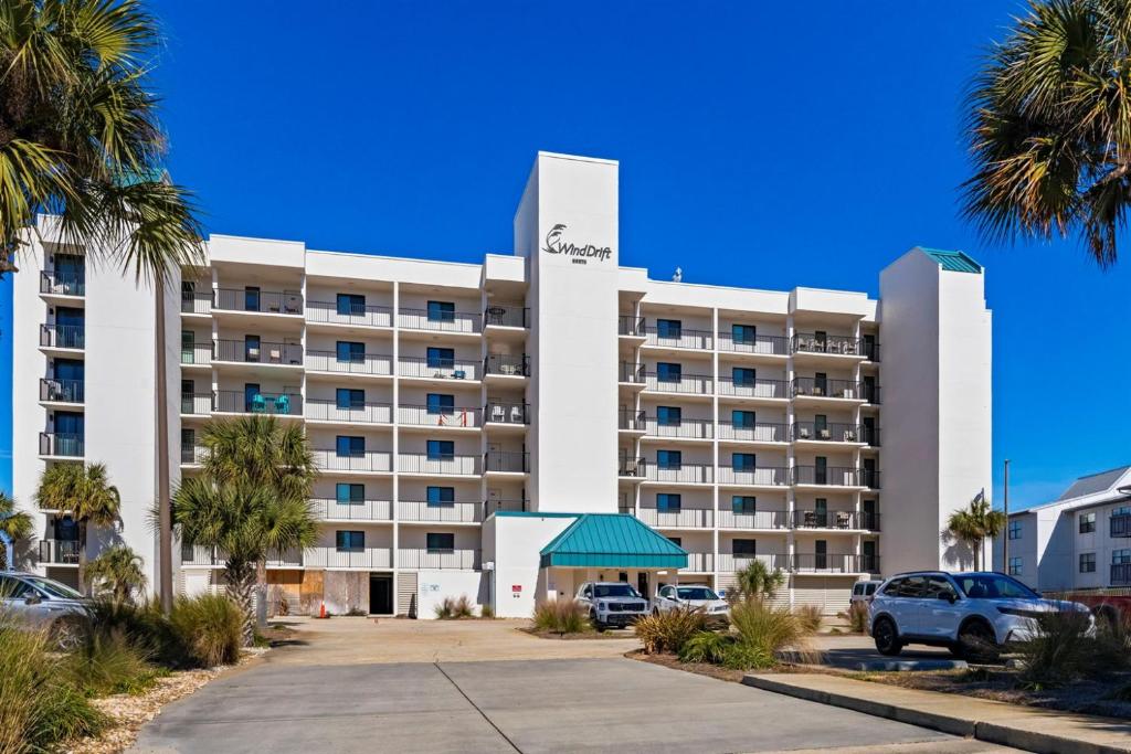 a large white hotel with cars parked in a parking lot at Wind Drift North 214 2BD, 2BA in Orange Beach