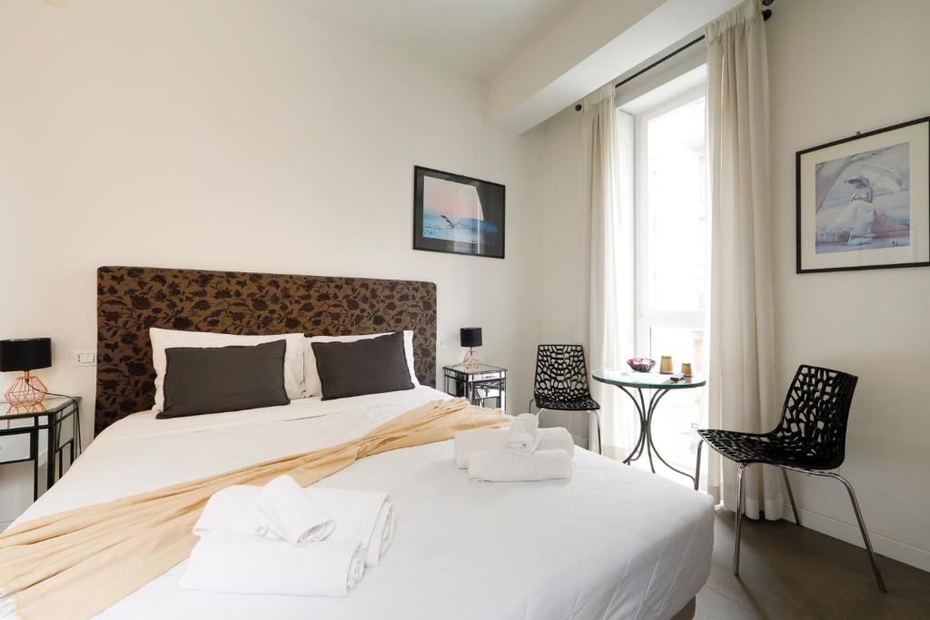 a white bedroom with a large bed and a window at G House in Bologna
