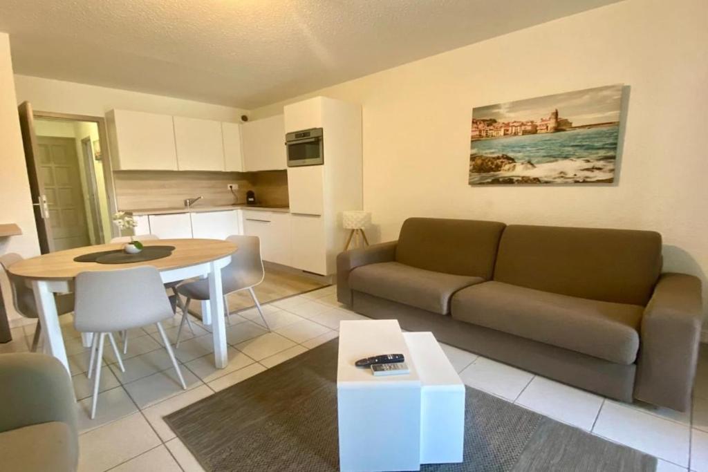 a living room with a couch and a table at Barcaresa - Malibu village Catalan T2 terrasse in Canet-en-Roussillon