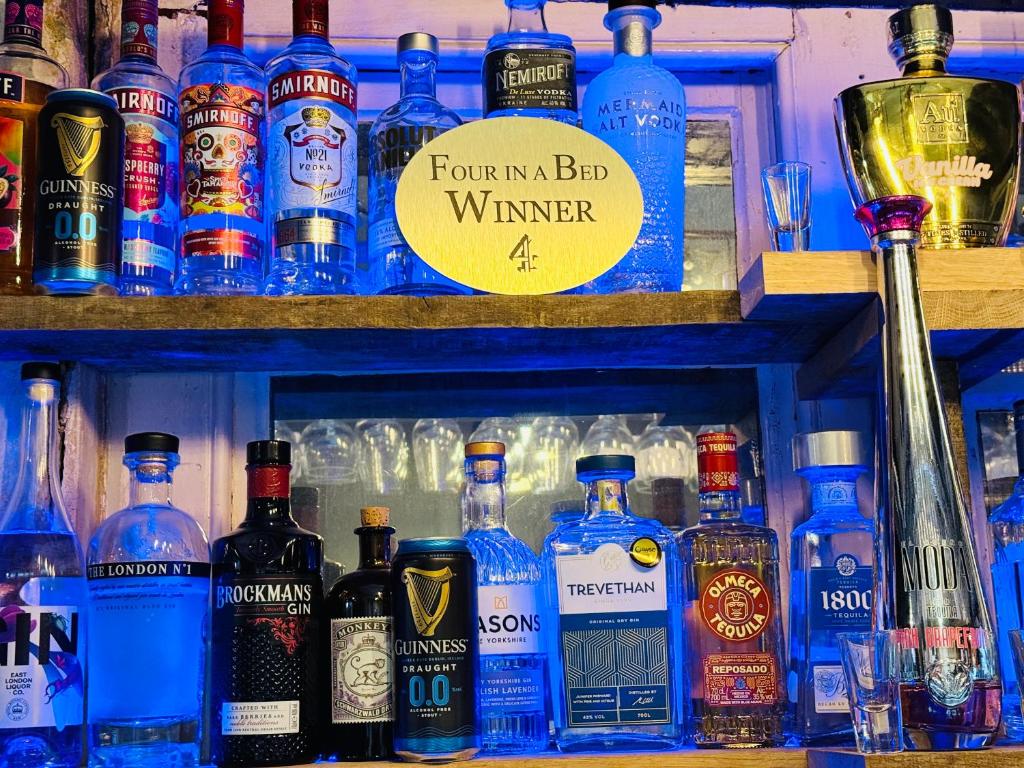 a bar with many bottles of alcohol on a shelf at The Vale Hotel in Cricklade
