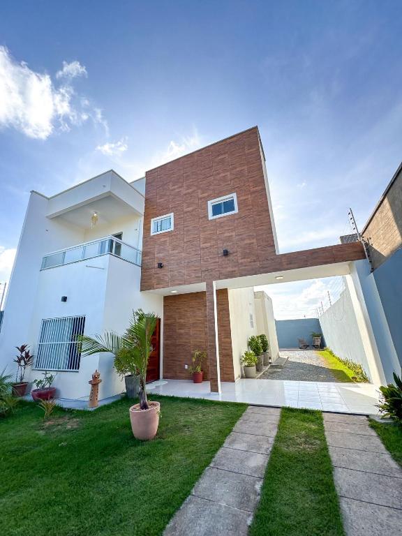 una gran casa blanca con una pared de ladrillo en Eficiência - Casa Dascli - Sua Casa em Camocim, en Camocim