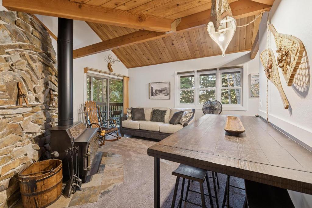 a living room with a stone fireplace and a table at Nordic Nook in Whitefish