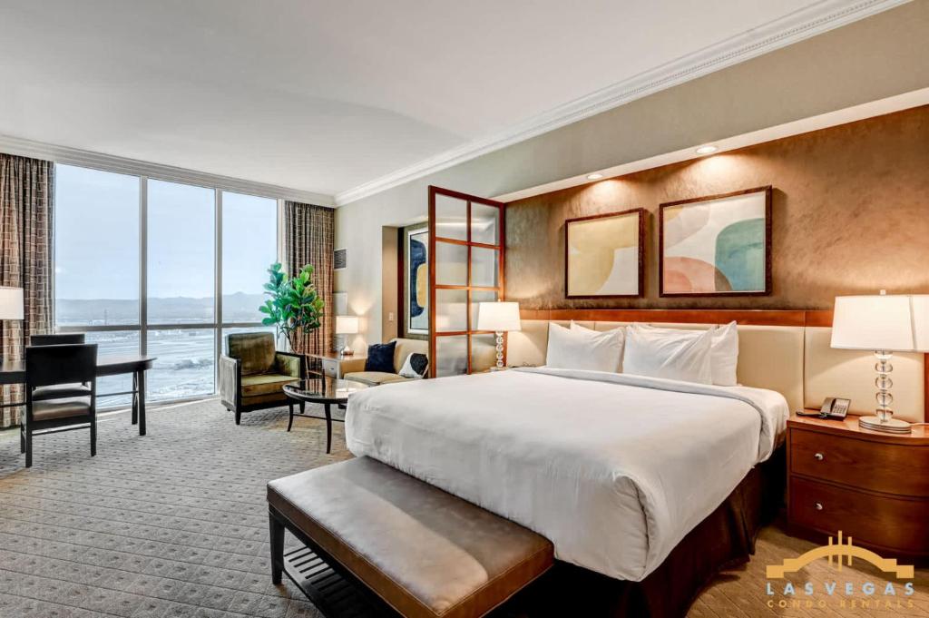 a hotel room with a large bed and a desk at MGM Signature 34-818 Jacuzzi Studio Upper Penthouse in Las Vegas
