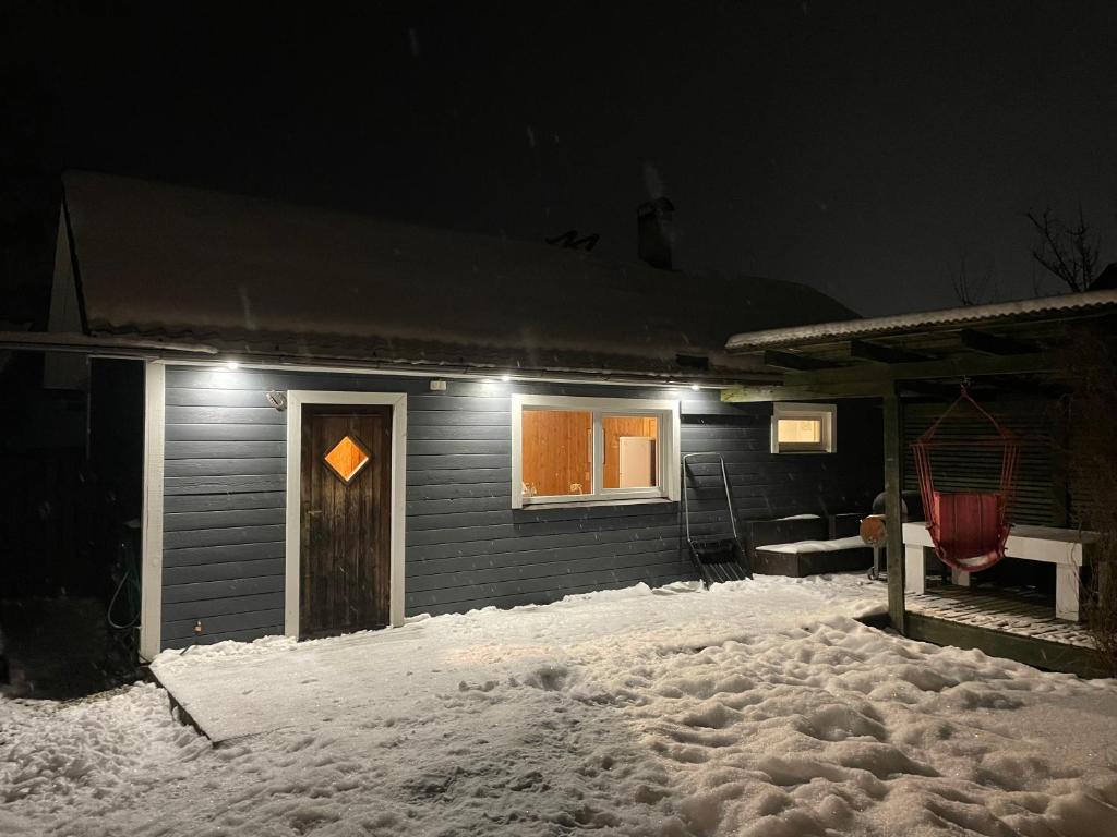 a house in the snow with lights on it at Pusa Saunamaja in Jõhvi