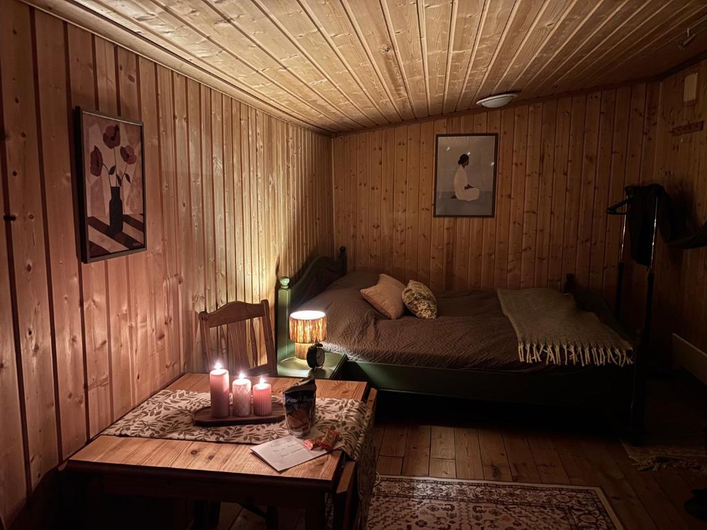 a bedroom with a bed and a table with candles at Musekroken in Elverum