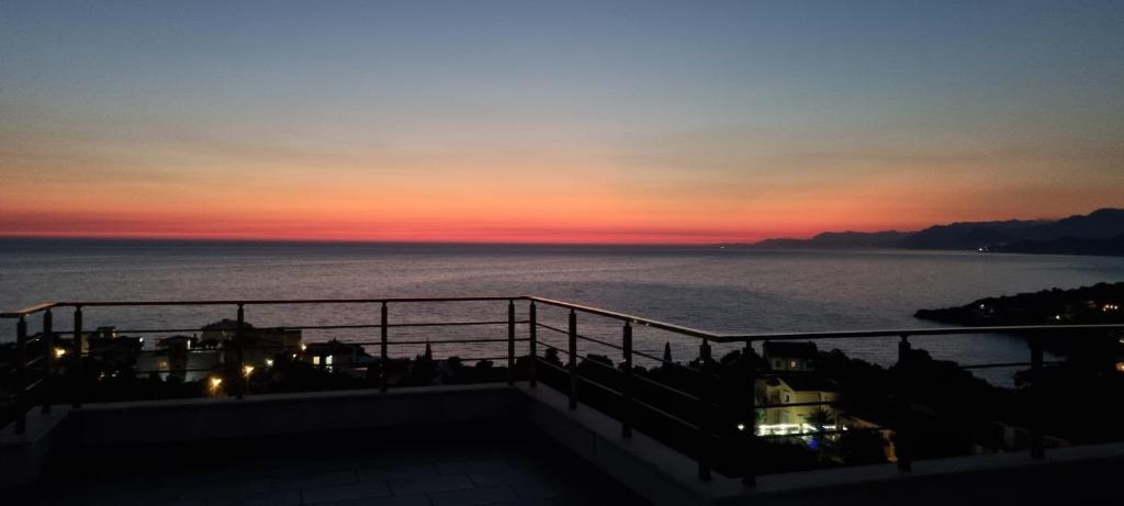 a view of the ocean at sunset from a balcony at Cold Bay Mansion Luxury Sea View Suites in Bar