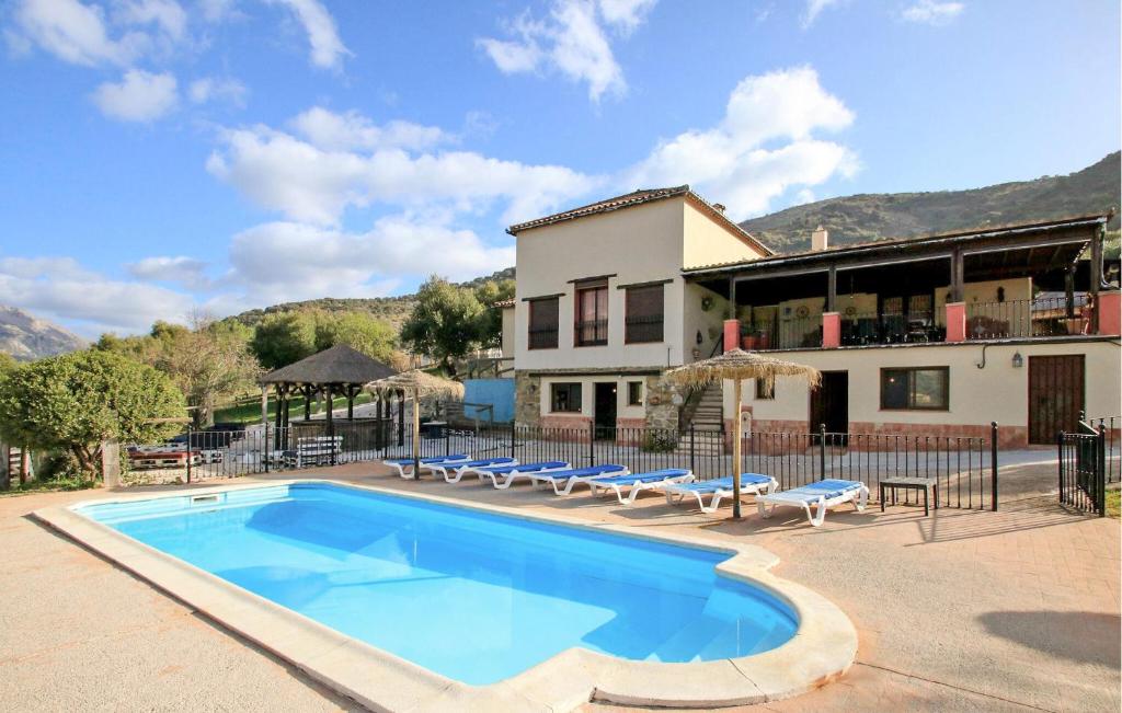 a swimming pool in front of a building with a house at Casa Rural Montion in Jimera de Líbar