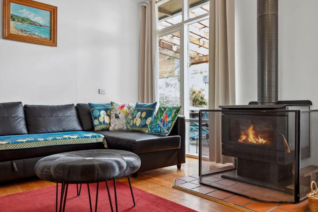 a living room with a couch and a fireplace at Moonah on Mawson in Anglesea
