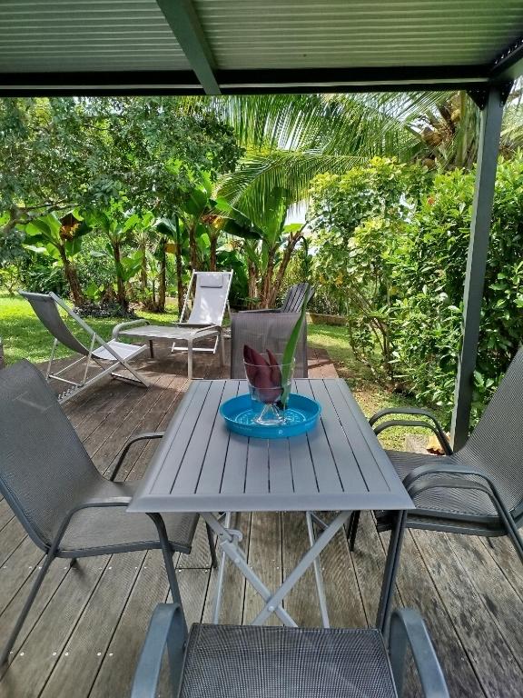a picnic table and chairs on a deck at Les poinsettias in Les Trois-Îlets
