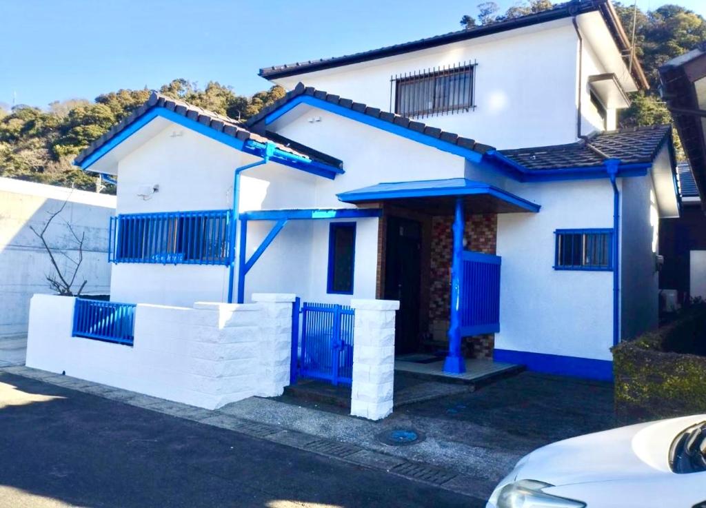 a white house with blue trim at Aoshima in Kisaki