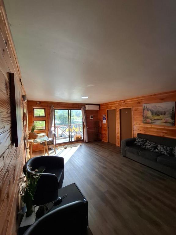 a living room with a couch and a chair at Habitación privada en Coñaripe de 1 Cama in Coñaripe