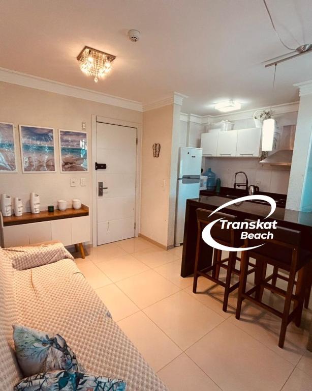 a kitchen and living room with a couch and a table at Summer Beach 300 mt da praia com amplo lazer e mobília nova in Bombinhas