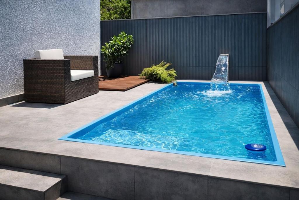 a swimming pool with a fountain in a backyard at Pousada 8 Mares in Arraial do Cabo