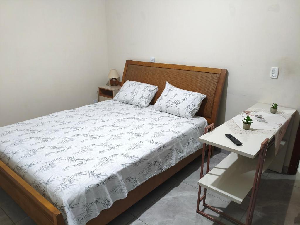 a bedroom with a bed and a side table at Hosting Altos da cidade perto de tudo in Bauru