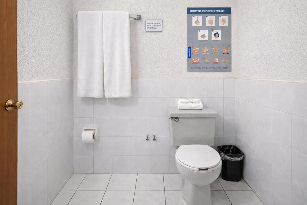 Un baño blanco con inodoro y toalla. en Blue Pacific Suites, en Mazatlán