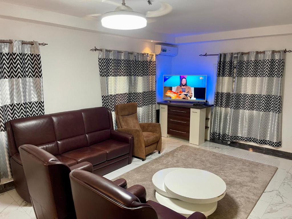 a living room with a couch and a tv at Tranquil Stay Tunereng in Tujering