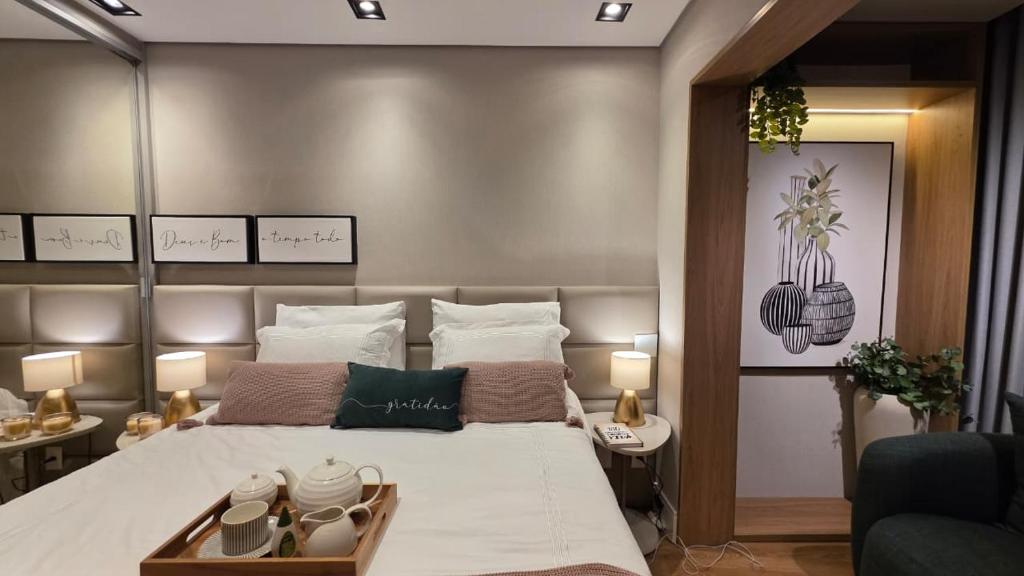 a bedroom with a large bed and a couch at Studio Lumière Moema in São Paulo