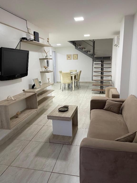 a living room with a couch and a tv and a table at Karina Apartamentos in La Rioja