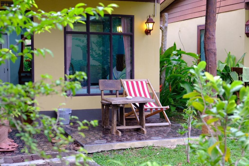 a chair and a table in front of a house at Sonya Kohlanta in Ko Lanta