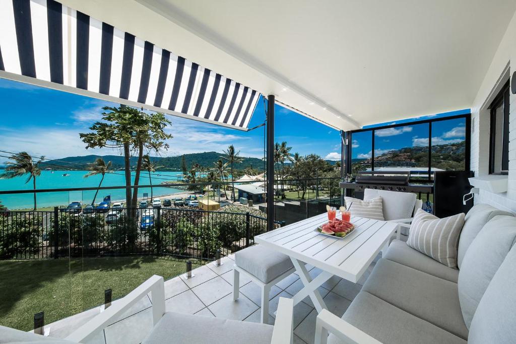 a living room with a white couch and a table at Broadwater Breeze in Airlie Beach