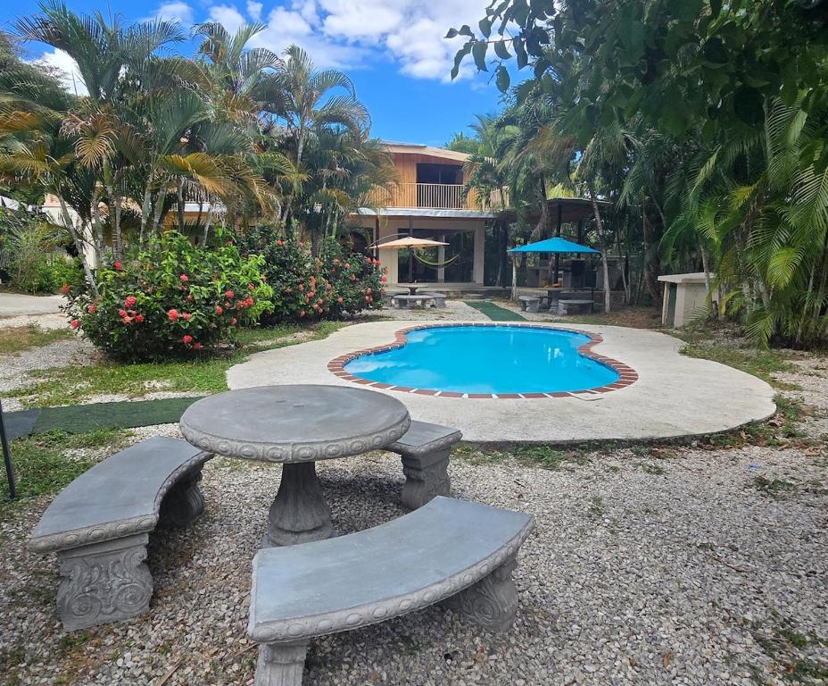 a table and chairs next to a swimming pool at Casa Las Brisas in Nicoya