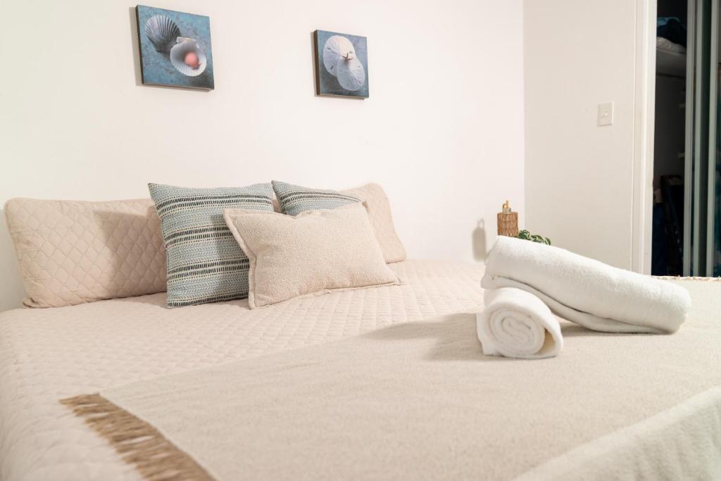 una camera da letto bianca con un letto bianco con cuscini di Beachfront Wave at Isla Verde a San Juan