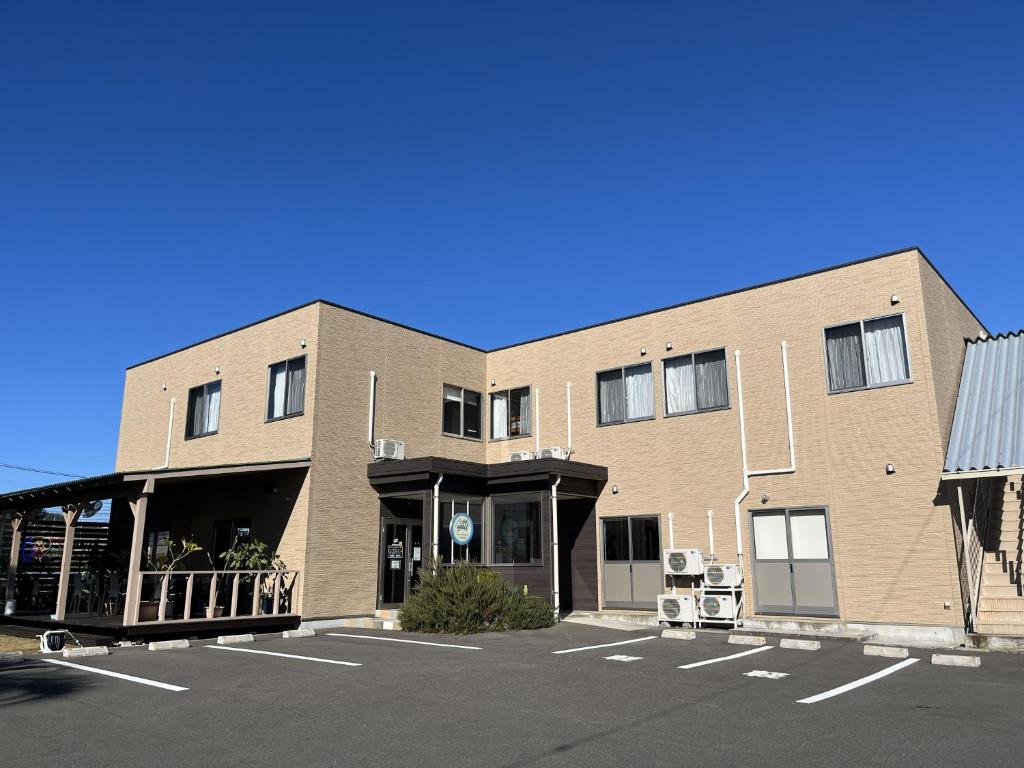 a brick building with a parking lot in front of it at SWELL in Hyuga