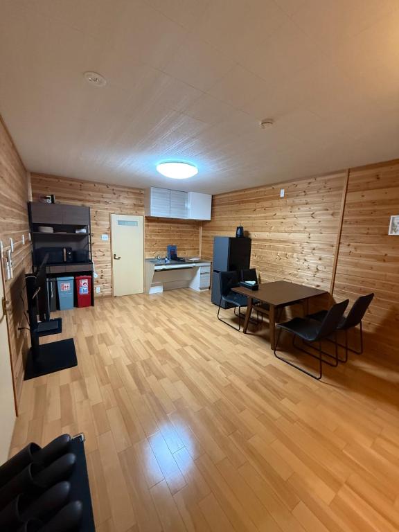 ein Wohnzimmer mit Tisch und Stühlen und eine Küche in der Unterkunft 最大4名の城ノ浜プール近くの宿 in Kihokucho