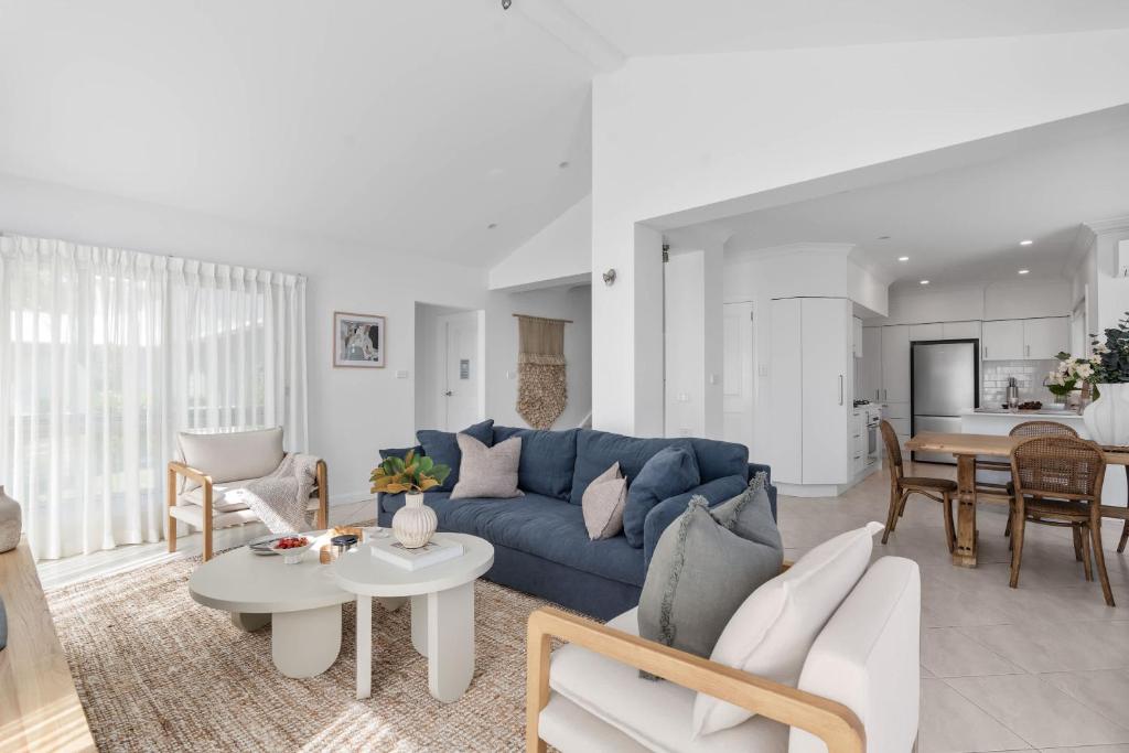 a living room with a blue couch and a table at Husky Salt in Huskisson